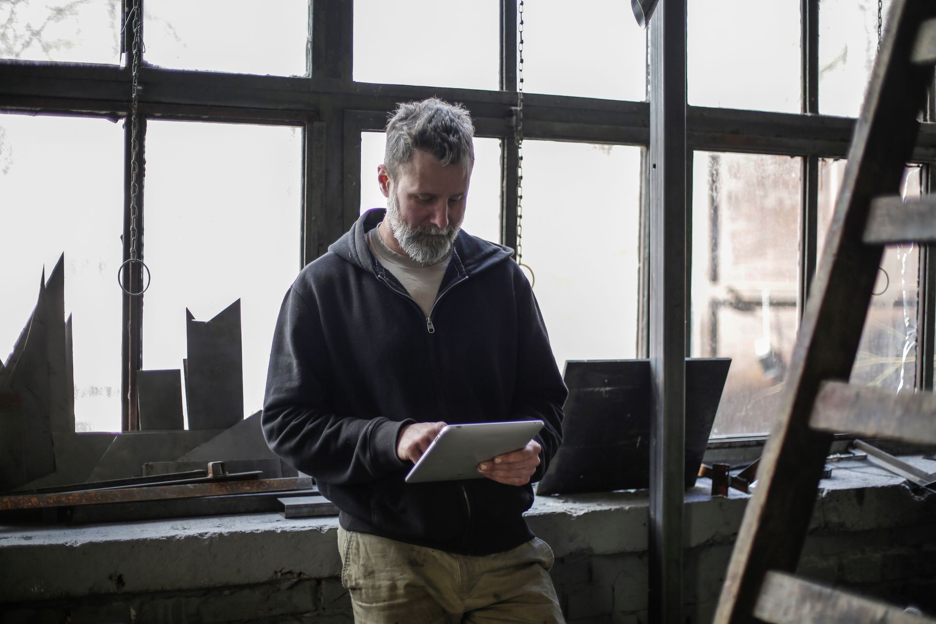 Artisan qui gère son entreprise depuis une tablette dans son atelier — Le mode autonomie. Le mode liberté. Le mode toi.
